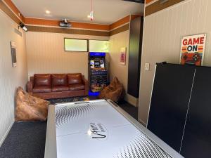 ein Spielzimmer mit einer Tischtennisplatte und einer Couch in der Unterkunft Seventeen on Cheltenham in Hanmer Springs