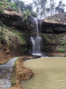 een waterval en een waterpoel naast een kreek bij Cabana Penélope in Alfredo Wagner