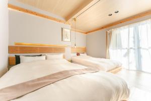 two beds in a room with a window at Cellar 88 in Sonogi