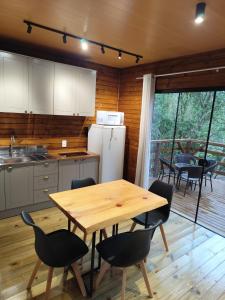 een keuken en eetkamer met een tafel en stoelen bij Cabana Penélope in Alfredo Wagner