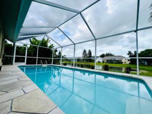 una piscina coperta con una grande serra di Sovanita House Naples, FL a Naples