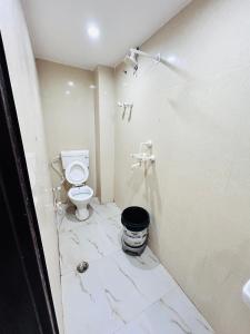 ein weißes Bad mit einem WC und einem Eimer in der Unterkunft shri radha ji guest House in Vrindāvan