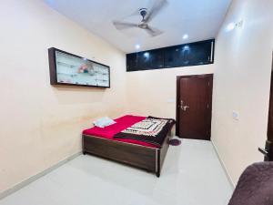 ein kleines Zimmer mit einem Bett und einem Flachbildfernseher in der Unterkunft shri radha ji guest House in Vrindāvan