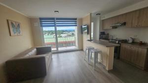 a living room with a couch and a kitchen at Departamento Villarrica in Villarrica