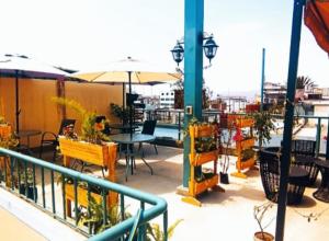 een balkon met tafels en stoelen en een parasol bij Santa Marta Casona in Arequipa +8 foto's