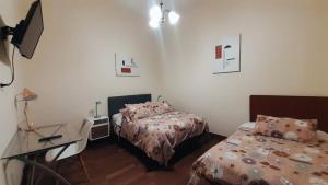 een kleine slaapkamer met 2 bedden en een bureau bij Santa Marta Casona in Arequipa