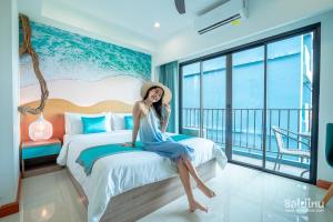 een vrouw op een bed in een hotelkamer bij Jomtien Beach Market Place in Jomtien Beach