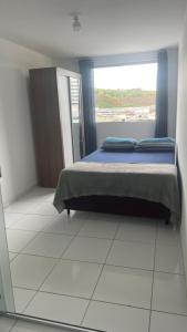 een slaapkamer met een bed en een groot raam bij Apartamento 3 Quartos Praça Cel Tibúrcio Barra in Muriaé