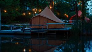 a tent on a dock in the water at night at KARIBU - Olifant in Kasterlee