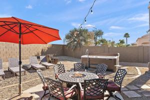 a patio with a table and chairs and an umbrella at Sleeps 14 Pool Fire Pit Billiards EV Plug in Mesa