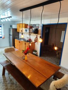 Cette chambre comprend une table en bois et une cuisine. dans l'établissement Sossego na Serra Catarinense - Casa em Lages, à Lages