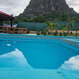 een zwembad met een berg op de achtergrond bij Villa Monte Alba in San Felipe de Puerto Plata