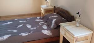 een bed met een paars dekbed en een nachtkastje bij La Calandria in Cerrillos