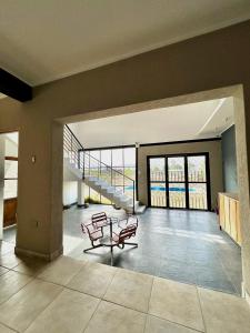 een woonkamer met stoelen, een tafel en een trap bij La Calandria in Cerrillos