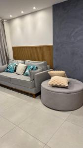 ein Wohnzimmer mit Sofa und Tisch in der Unterkunft Guarajuba Flat Acqua 103 in Camassari