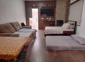 un soggiorno con 3 letti e un divano di ESTÚDIO "Coisa de Daiane" a São Gabriel