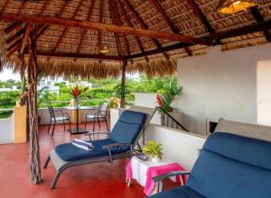 埃斯孔迪多港Hotel Zandoyo Bed & Breakfast的一个带桌椅的庭院和屋顶