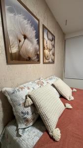 a bedroom with a bed with three pictures on the wall at Guarajuba Acqua 103 in Camacari +31 photos