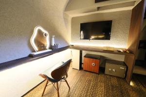a hotel room with a chair and a television at 水と翠 in Gujo