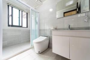 een witte badkamer met toilet en douche bij 巨翼包棟民宿 in Puli +18 foto's