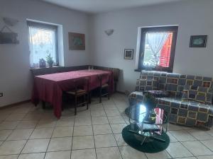 een woonkamer met een tafel en een bank bij Casa Cappuccetto in Imer +2 foto's