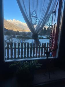 een raam met een hek en uitzicht op een berg bij Casa Cappuccetto in Imer