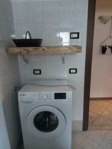 een wasmachine met een houten plank erboven bij Casa Cappuccetto in Imer