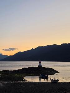 a lighthouse on a small island in the water at Cabañas cochamó in Cochamó
