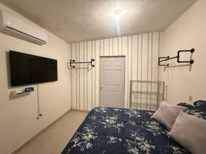 une chambre avec un lit et une télévision à écran plat dans l'établissement Moderno, Practico y Acogedor, à La Paz