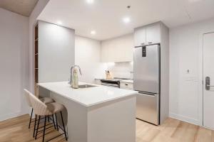 una cucina con mobili bianchi e un frigorifero di Charming condo in Rosemont a Montréal Altre 12 foto