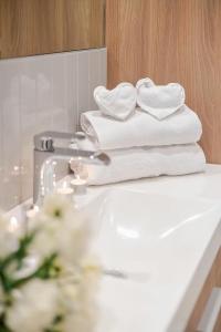 una pila di asciugamani poggiata sopra un lavandino del bagno di Charming condo in Rosemont a Montréal