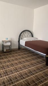 a bedroom with a bed and a side table at Kuku Ruku Hotel in Querétaro