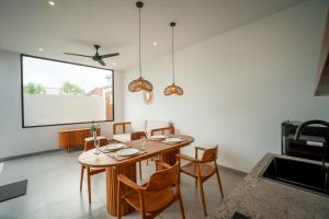 een eetkamer met een houten tafel en stoelen bij Snuggy Shack Villas in Munggu +10 foto's