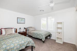 a bedroom with two beds and a window at Verona in Shoal Bay