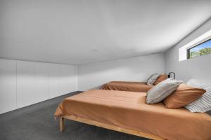 a bedroom with two beds and a window at Tathra Bermagui Road 613 in Tathra