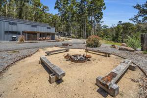 a dirt area with a fire pit and a building at Tathra Bermagui Road 613 in Tathra