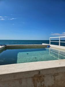 een zwembad met de oceaan op de achtergrond bij Oceanfront paradise live the experience in Campeche