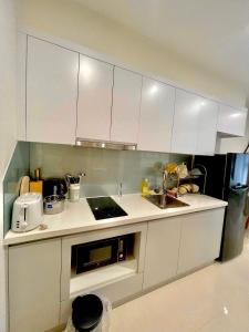 a kitchen with white cabinets and a sink at Căn hộ Studio 33m2 tòa S217 in Gia Lâm Pho