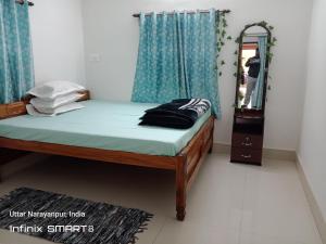 Schlafzimmer mit einem Bett mit blauen Vorhängen und einem Spiegel in der Unterkunft Swpnaneer home stay in Shānti Niketan + 19 Fotos