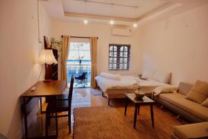 a room with a bed and a desk and a couch at KUHA home in Nha Trang