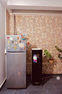 a refrigerator with magnets on a stone wall at KUHA home in Nha Trang