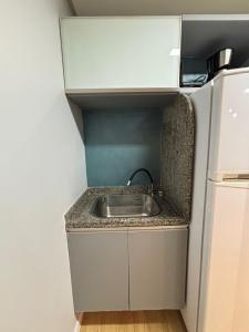 eine kleine Küche mit Spüle und Kühlschrank in der Unterkunft Flat Rosarinho III - Confortável e Super Completo in Recife