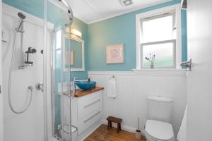 een badkamer met een douche, een toilet en een wastafel bij Plum Coastal Cottage in Raumati Beach +53 foto's