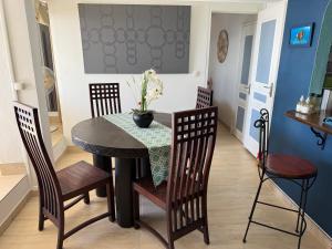 a dining room with a table with chairs and a vase on it at Brise Marine Sxm in Marigot