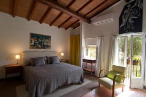 sypialnia z łóżkiem, krzesłem i oknami w obiekcie Il Monasteraccio we Florencji