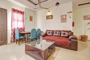 a living room with a couch and a table at Super Hotel O Glorious Stayz in Noida