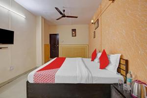 a bedroom with a bed with red pillows at Super Hotel O Glorious Stayz in Noida