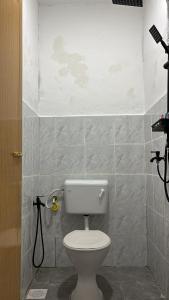 a bathroom with a white toilet in a room at Trong Roomstays in Terong +14 photos