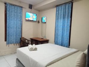 a bedroom with a bed and a table and a tv at Pakemsari Resort Hotel in Pakem
