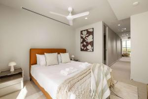 een slaapkamer met een groot bed met witte lakens bij Luxury Beachside Escape in Palm Beach NEW 2BR in Gold Coast +13 foto's